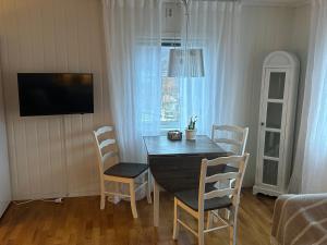 a dining room with a table and chairs and a television at Koselig hus i Beisfjord in Narvik