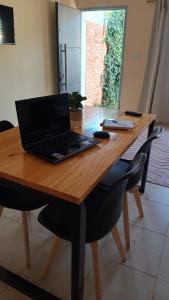 a laptop computer sitting on top of a wooden table at Once Reinas Departamentos in San Rafael