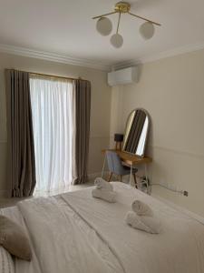 a bedroom with a bed with two towels on it at Perlina Naxxar in Naxxar