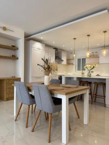 a kitchen with a wooden table and chairs at Perlina Naxxar in Naxxar