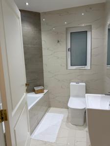 a bathroom with a toilet and a television on the wall at Perlina Naxxar in Naxxar