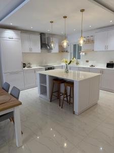 a kitchen with white cabinets and a table with flowers on it at Perlina Naxxar in Naxxar +14 photos