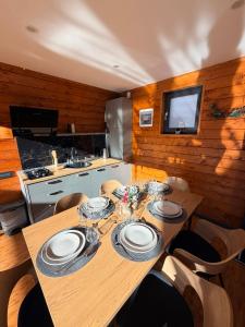 a dining room with a wooden table with chairs and a television at Twin Cabins Azuga in Azuga