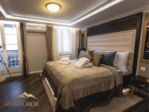 a bedroom with a large bed with two towels on it at Boutique Hotel Himmelrich in Lucerne