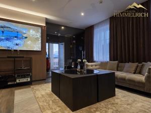 a living room with a couch and a flat screen tv at Boutique Hotel Himmelrich in Lucerne