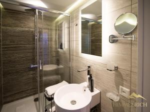 a bathroom with a sink and a glass shower at Boutique Hotel Himmelrich in Lucerne +23 photos