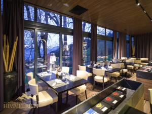 a restaurant with tables and chairs and large windows at Boutique Hotel Himmelrich in Lucerne