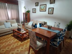 a living room with a wooden table and chairs at A Ribeira in Fene