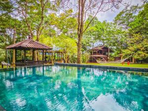 a swimming pool with a gazebo and a playground at Templer Park Rainforest Retreat TPRR in Rawang