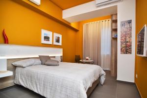 a bedroom with orange walls and a large bed at Bed In Centro in Naples