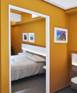a bedroom with yellow walls and a bed with a mirror at Bed In Centro in Naples