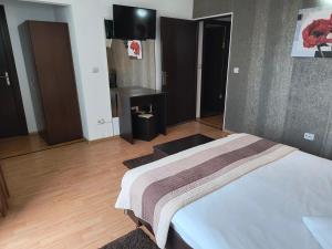 a bedroom with a bed and a flat screen tv at Casa Mais Brașov Guesthouse with Free Parking in Braşov