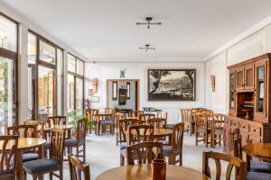 a restaurant with wooden tables and chairs and windows at Hostal Nadal in Sóller +84 photos