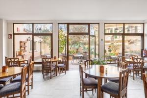 a restaurant with tables and chairs and windows at Hostal Nadal in Sóller