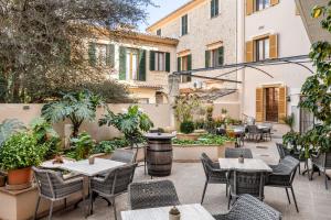 an outdoor patio with tables and chairs and plants at Hostal Nadal in Sóller