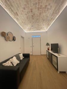 a living room with a couch and a television at Cledo Mare Luxury Stay - Armonia in Pescara