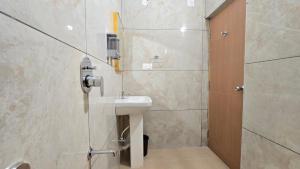 ein Badezimmer mit Waschbecken und Dusche in der Unterkunft Hotel Simha Skylight - Tirupati in Tirupati