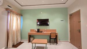 ein Zimmer mit Tisch, Stühlen und Waschbecken in der Unterkunft Hotel Simha Skylight - Tirupati in Tirupati