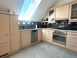 a kitchen with wooden cabinets and a skylight at Ferienwohnung Glücksklee in Tharandt