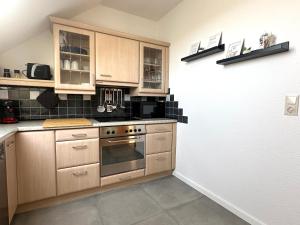 a kitchen with wooden cabinets and a stove at Ferienwohnung Glücksklee in Tharandt +8 photos