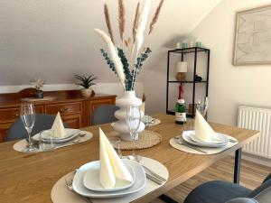 a dining room table with plates and napkins on it at Ferienwohnung Glücksklee in Tharandt