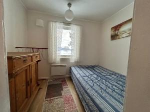 a bedroom with a bed and a dresser and a window at Old farm house & sauna in Stunes