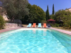 a swimming pool with lounge chairs and a group at L'Escale Provençale in Tourrettes