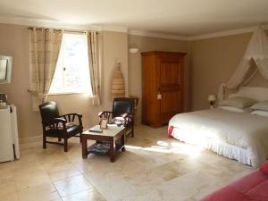 a bedroom with a bed and chairs and a table at L'Escale Provençale in Tourrettes +8 photos