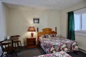 a bedroom with a bed and a table and a window at Bennett Lodge in Daniels Harbour