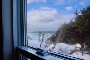 a window with a view of a snow covered beach at Bennett Lodge in Daniels Harbour