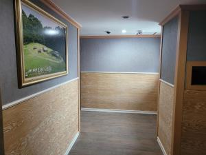 a room with a painting on the wall and a television at 힐하우스 in Chŏngp'op'ogu +3 photos