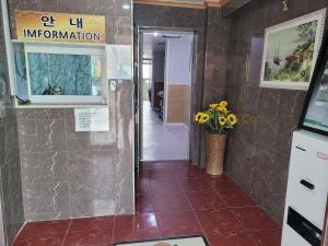 a hallway with a tile floor and a door with a vase of flowers at 힐하우스 in Chŏngp'op'ogu