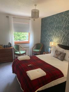 a bedroom with a bed with two towels on it at Lochview Guest House in Ullapool