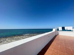 a view of the ocean from the balcony of a house at SeaSide Paradise - Seafront Terrace Apartment by BariHouses in Cozze +2 photos