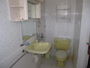 a small bathroom with a yellow toilet and a sink at Casa Playas # 1 in Playas +22 photos