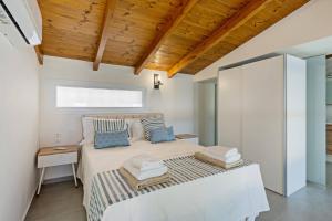 a bedroom with a bed and a wooden ceiling at MyPanormo Suites - Philip in Panormos Rethymno