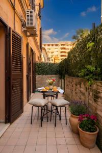 a patio with a table and chairs and flowers at Heart of Pescara Elegant Suites - Chic Suites in Pescara Center & 2 steps from Sea - AC & Wifi in Pescara