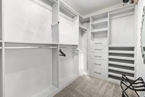 a white walk in closet with white shelves at Pet-Friendly 4BR Oasis - Heated Pool Firepit & BBQ in Chandler