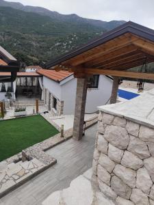 a house with a stone retaining wall and a wooden roof at Villa Vilić in Vrgorac