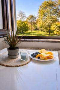 a plate of fruit on a table next to a window at LaBohème Lake Maggiore Retreat with Private Beach in Dormelletto
