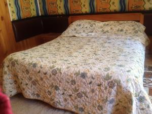 1 cama con edredón de flores en un dormitorio en Caulín Lodge, en Chacao