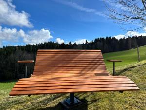 a wooden bench sitting on top of a field at Apfel-Stadl "Gala", Oberreute in Oberreute +4 photos