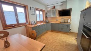 a kitchen with gray cabinets and a wooden floor at Apfel-Stadl "Gala", Oberreute in Oberreute