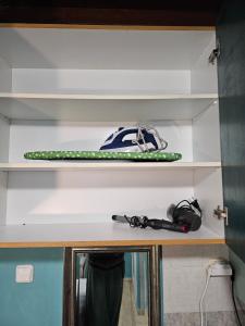 a surfboard and other items on a shelf at CaN-CaN in Mikonos