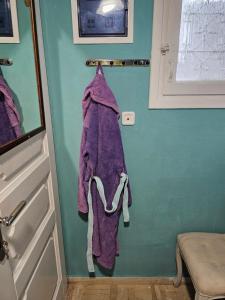 a purple towel hanging on a wall next to a door at CaN-CaN in Mikonos