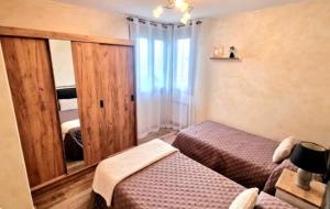 a bedroom with two beds and a large window at Villa Galana Oyambre in Los Llaós