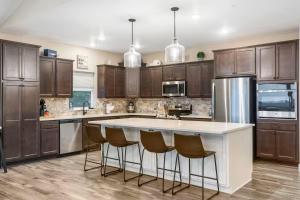 a kitchen with wooden cabinets and a white island with bar stools at On the Rocks Lodge in Branson