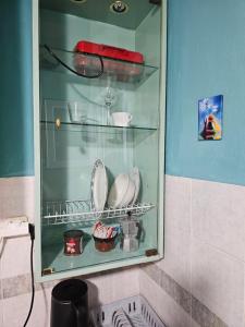 a glass cabinet with dishes in it in a bathroom at CaN-CaN in Mikonos +9 photos