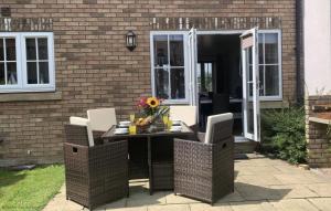 a patio with a table and chairs and a building at Sunset Cottage - Part of the The Bay Filey Holiday Village with pool, gym and direct beach access, pub, restaurant, tennis and meadows walks in Filey +43 photos