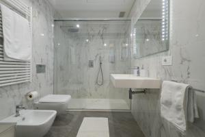 a white bathroom with a sink and a toilet at Bergamo SottoSopra Gold in Bergamo +16 photos